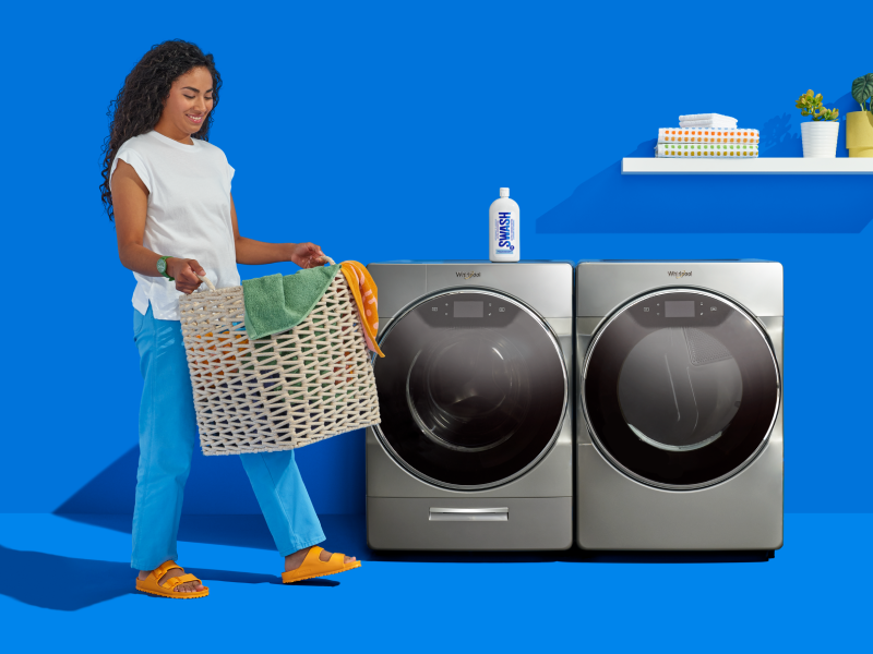 Woman carrying a basket of laundry infront of a Whirlpool® Washer and Dryer Woman carrying a basket of laundry infront of a Whirlpool® Washer and Dryer