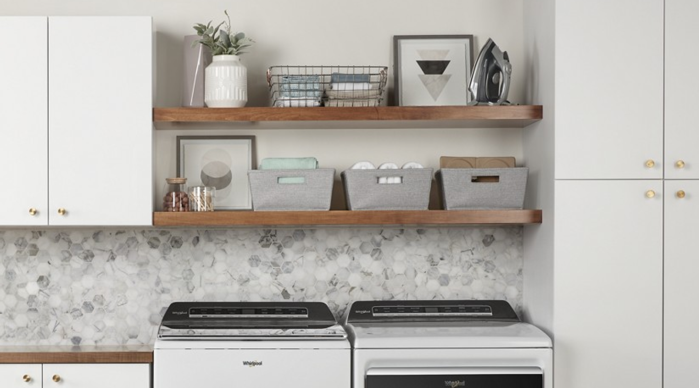 A neatly organized launndry room with a Whirlpool® waaher and dryer.