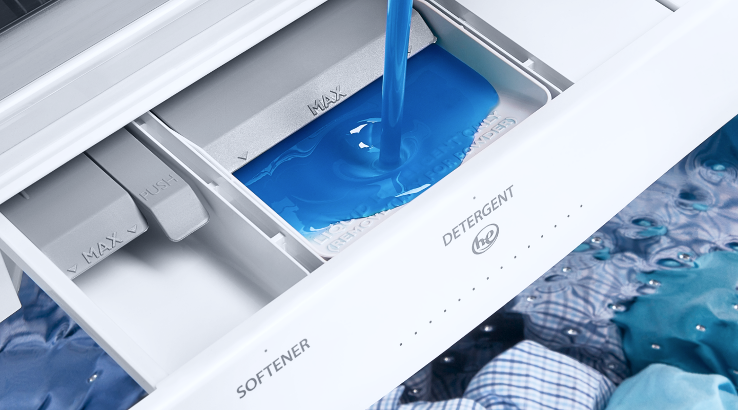 Blue liquid detergent being poured into a washing machine.