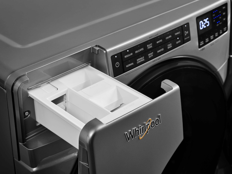 An open laundry detergent dispenser on a Whirlpool front load washing machine.